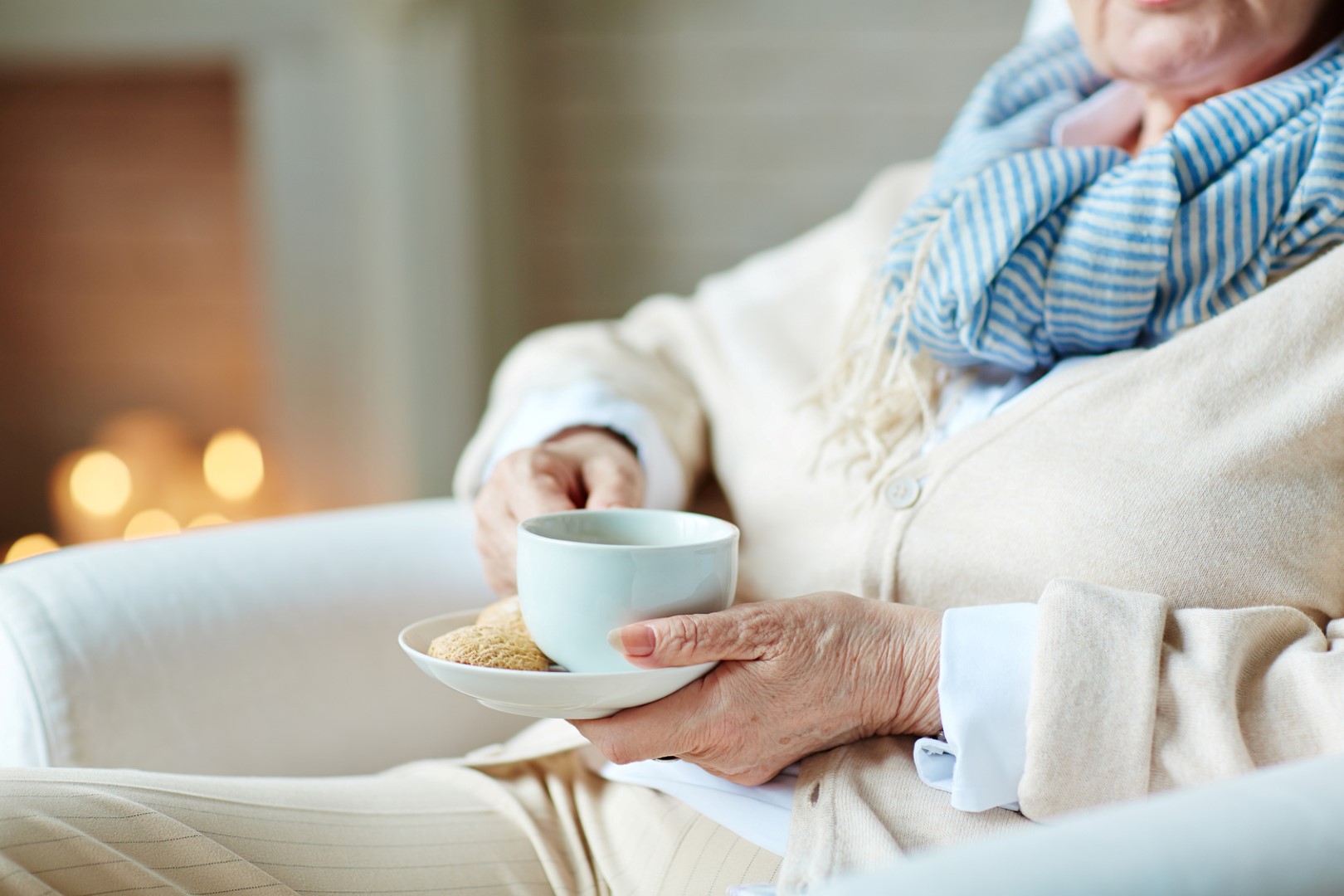 Cup of tea in hands of senior woman home care