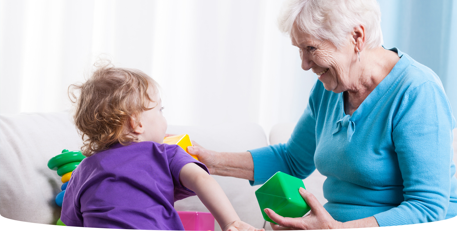 Grandmother and granddaughter playing with blocks home care